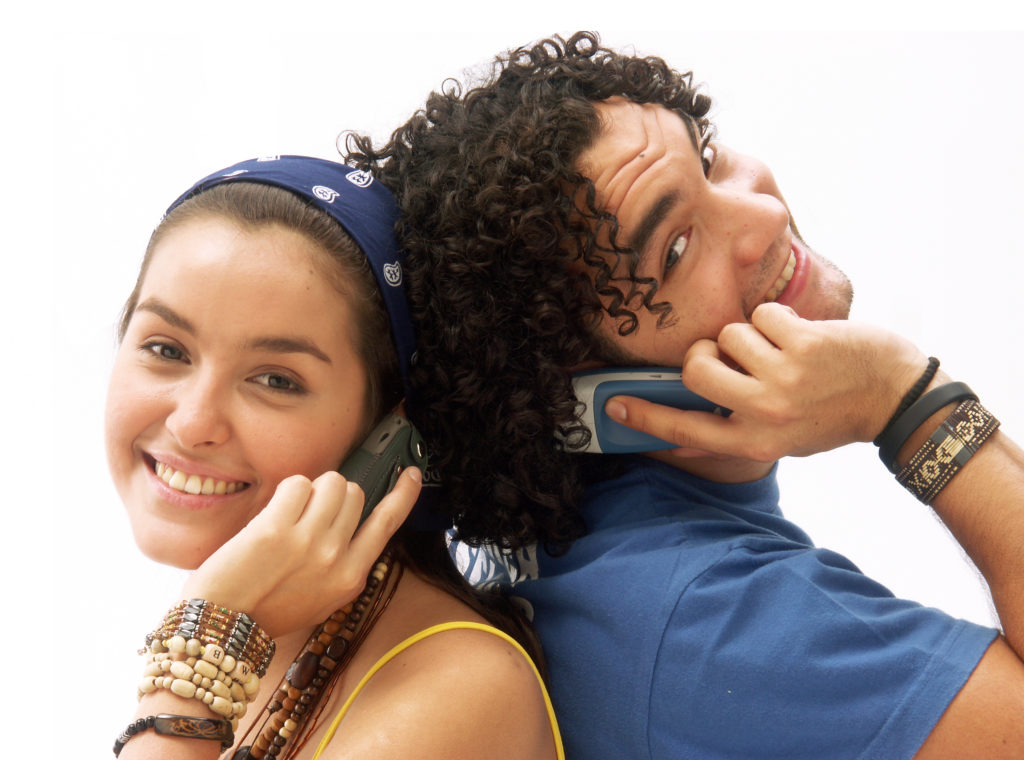 Young couple using a mobile phone. Young couple talking themselves by mobile phone.